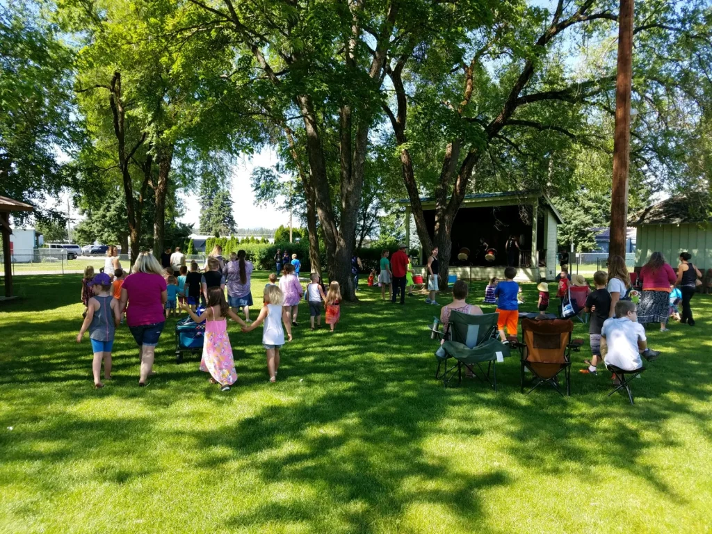 Families gathered on the shaded lawn at Athol City Park for a summer event