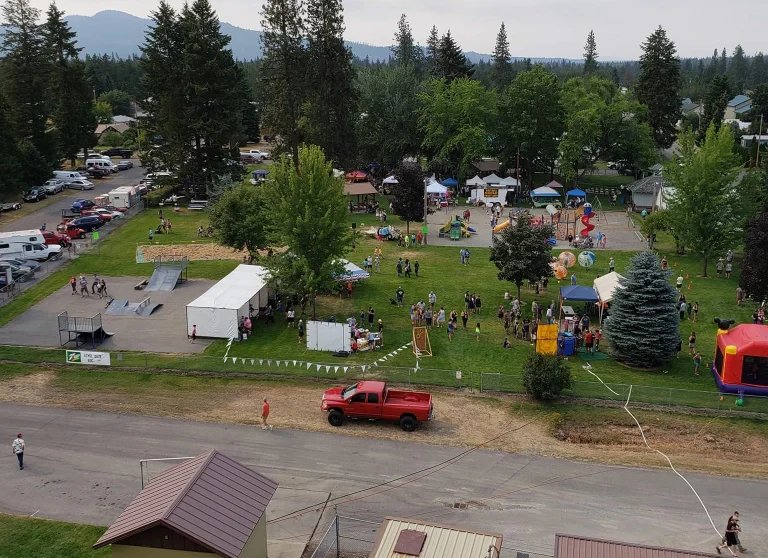 Aerial view of Athol City Park filled with booths, games and visitors during Athol Daze