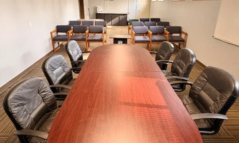 Council room with a long boardroom table and leather chairs